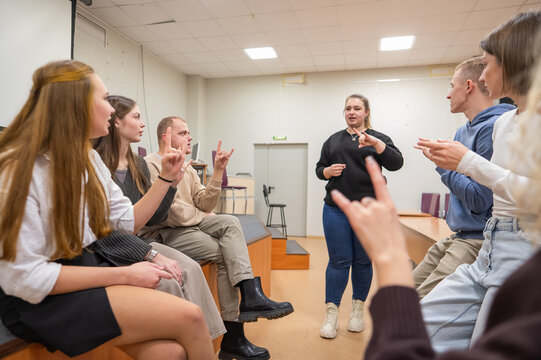 Young people communicate in sign language in a university classroom. 