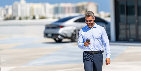 Business man chat on phone outdoor. Businessman chatting on phone. Businessman using smartphone. Handsome businessman chatting online. Businessman walking. Corporate business. Copy space banner