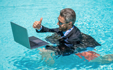 Freelance man has online video call. Freelance working online. Man using laptop for freelancing in swimming pool. Business freelancing. Businessman on summer vacation. Businessman on video conference