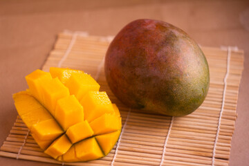 Ripe Mango with Sliced Cubes on Bamboo Mat Background
