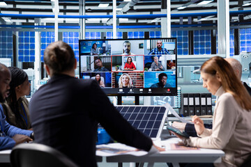 Manager in internet video call with buyers trying to secure funding during solar panels materials presentation. Businessman in industrial plant doing remote videoconference to pitch company assets