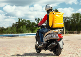 Food Delivery Service. Courier With Yellow Backpack Riding Scooter Delivering Restaurants Meals In...