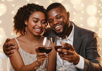 Portrait of happy african couple celebrating St. Valentine's Day at restaurant, drinking red wine...