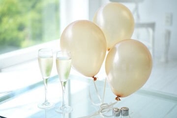 Celebration Still Life: Champagne Flutes and Balloons on a Glass Table for a Special Occasion or Party, Perfect for Wedding, Anniversary, or Birthday