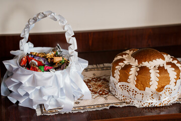 Traditional Easter Bread and Candy Basket Still Life: White Ribbon, Lace Doily, Wood Table, Festive...