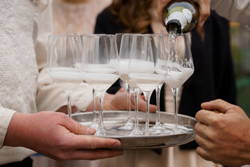 Sparkling Wine Toast Celebration: Champagne Pouring Into Glasses on Silver Tray at Wedding, Festive Moment, Bright and Airy Style