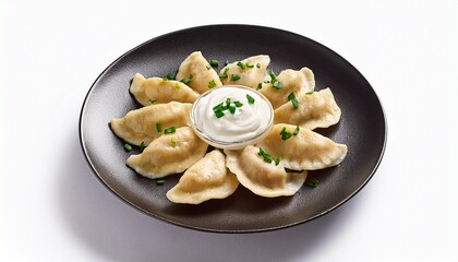 top view of polish pierogi with sour cream on a dark plate isolated on white background