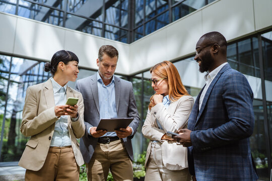 multiracial businesspeople review reports with business data charts