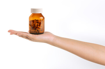 Hand holding a bottle of medicine isolated on white background.
