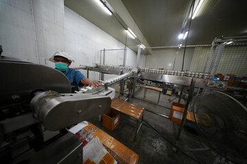 Worker operating machinery in a food processing facility during the day