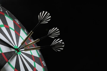 Targeting. Dart board with arrows on black background, closeup. Space for text