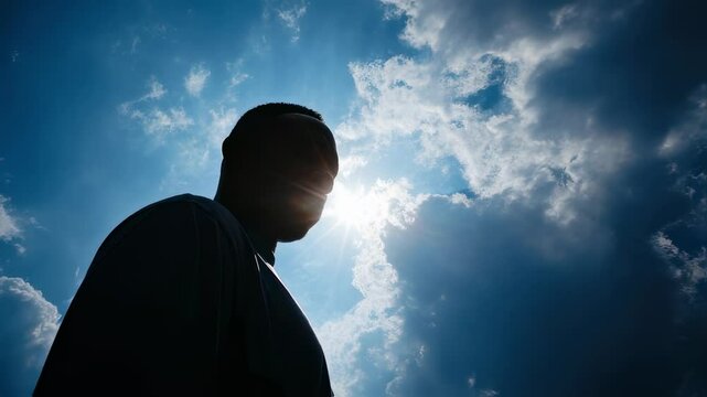 A person gazing up at the sky with a look of awe and wonder, symbolizing a strong sense of faith and belief in soing greater.