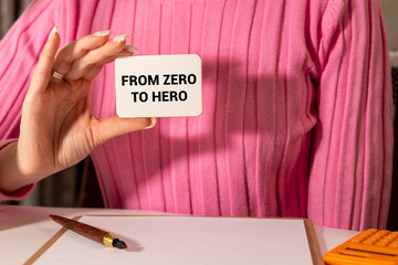 girl holds a card with the text From zero to hero
