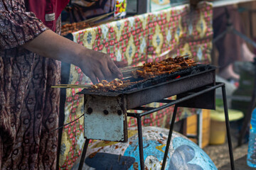 Grilling Satay Skewers at an Indonesian Food Stall