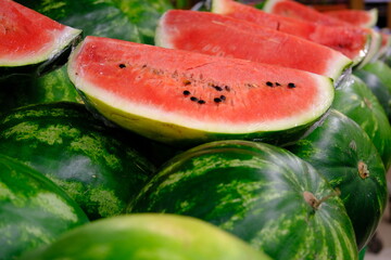 Fresh summer fruit watermelons sold in a market. Healthy vegan nutrition. Sliced ​​watermelons. Vitamin store watermelon. Vegetable and fruit prices in the greengrocer's. Organic farming. © arzu