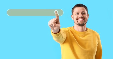 Happy young man using web search engine against blue background