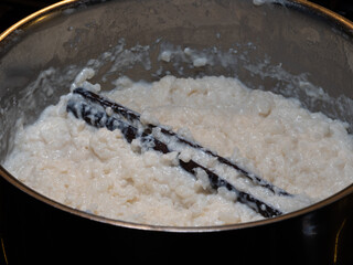Close-up of creamy Swedish rice pudding with a whole cinnamon stick in a pot, ready to serve for dessert or breakfast