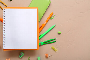 Blank notebook and different stationery on beige background