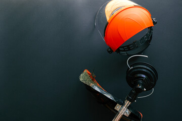 Brush cutter head with cutting line and protective safety helmet with face shield placed on black...