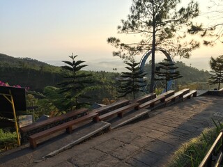 Naklejka premium Serene Sunrise Viewpoint Mountaintop Seating with Misty Valley Panorama