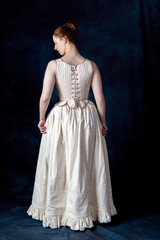 A Renaissance or Georgian woman wearing underwear consisting of boned stays and a corded petticoat