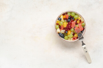 Bowl of fresh fruit salad on light background