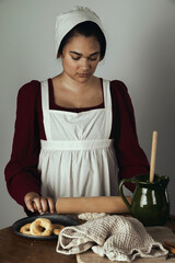 A Regency period working-class woman or servant making biscuits