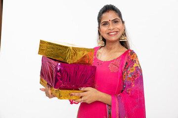 Excited and surprised Indian happy young woman holding gift boxes and standing on white. wearing...