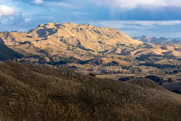 Rolling hills and farmland meet the ocean in this scenic landscape of Havelock North, Hawke's Bay, New Zealand. The image captures the natural beauty and rural charm of the country.