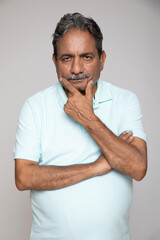 Indian senior man gesturing at camera isolated on grey studio background