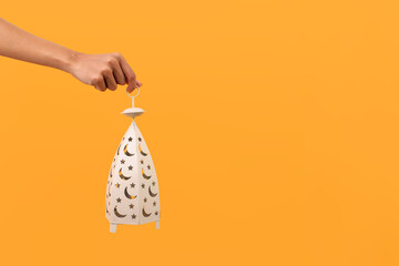 Hand Holding White Lantern With Moon And Star For Ramadan Concept Isolated On Yellow Background