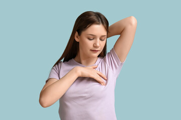 Young woman checking her breast  on blue background