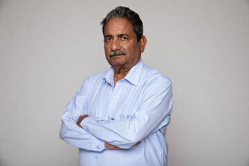 Indian senior man gesturing at camera isolated on grey studio background