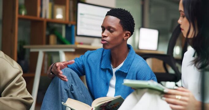 Man, students and explain with book in library for research, study session and education at college. Group, friends and advice for project, assignment and test preparation with information on thesis