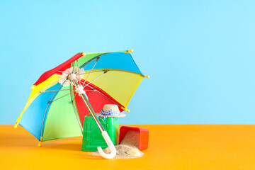 Seashell, sand, beach toy molds, decorative hat and umbrella on color background © Pixel-Shot