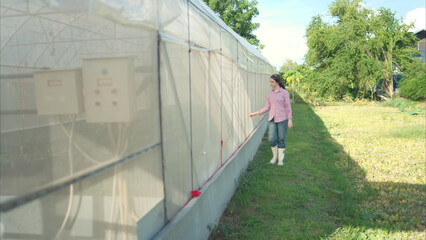 Young people examining plants in a greenhouse, learning about sustainable farming