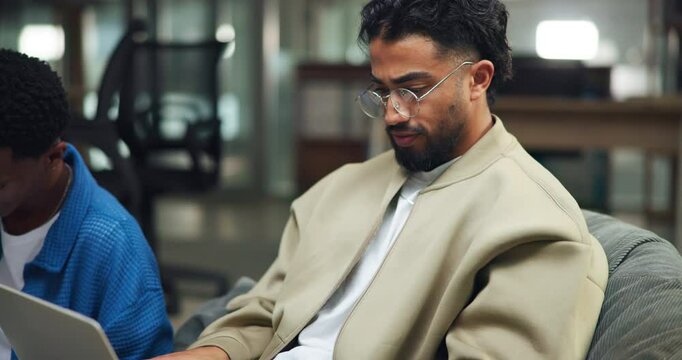 Man, student and reading on laptop in library for research, study session and education at college. People, online and group for project, assignment and test preparation for scholarship ay university