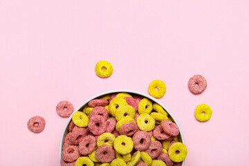 Bowl with tasty cereal rings on pink background, closeup