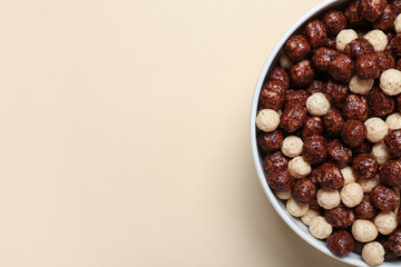 Bowl with tasty chocolate corn balls on beige background, closeup