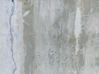 Weathered Concrete Wall with Cracks. A close-up of an aged and discolored concrete surface, exhibiting cracks and peeling paint, creating a grungy texture