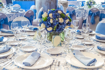 A table with a blue tablecloth and blue chairs