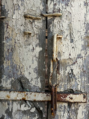 A rusty gate with a chain hanging from it