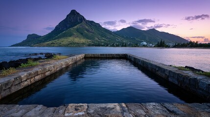 Tranquil harbor pool at sunset, reflecting a mountainous landscape.