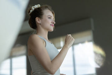 The athletic woman dressed in a black sportswear running on the treadmill in the modern gym