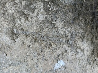 Rough Weathered Stone Texture. A close-up of an old, textured stone or concrete surface with varying shades of grey and dark patches