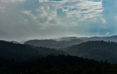 Misty mountains with dense forests and cloudy skies, serene landscape in Meghalaya.