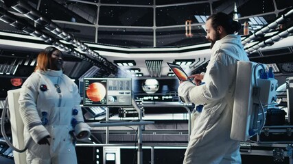 Team of astronauts in advanced technology spacecraft checking red planet summary analytics during routine mission check. Teamworking orbit station crew members using device to look at Mars data