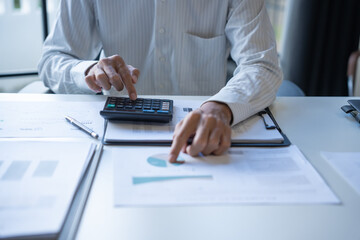 Male Professional Using Calculator for Business Budget Analysis.