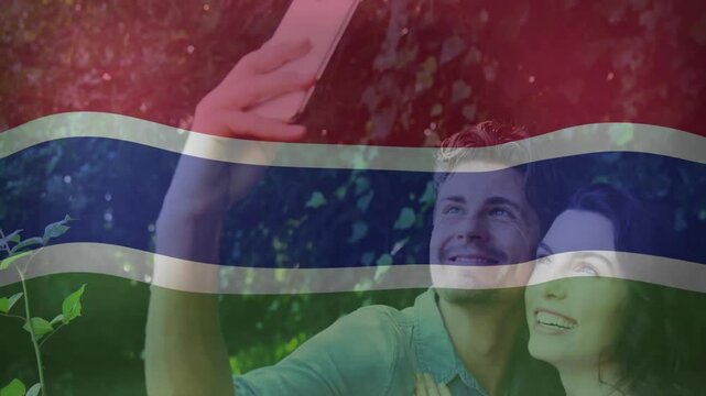 man extending smartphone woman leaning flag pattern sliding over faces taking social media selfie