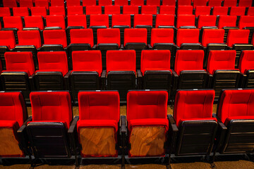 Fototapeta premium Rows of red seats in an auditorium or cinema hall. Evokes entertainment, leisure, and culture.